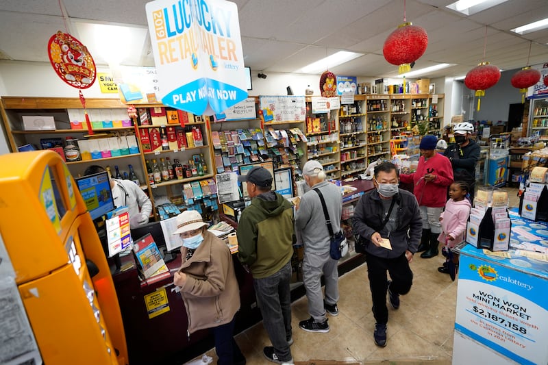 Madeline Copper, second from right, and her granddaughter, Lay-Lonnie, 5, stand in line to buy Powerball lottery tickets.