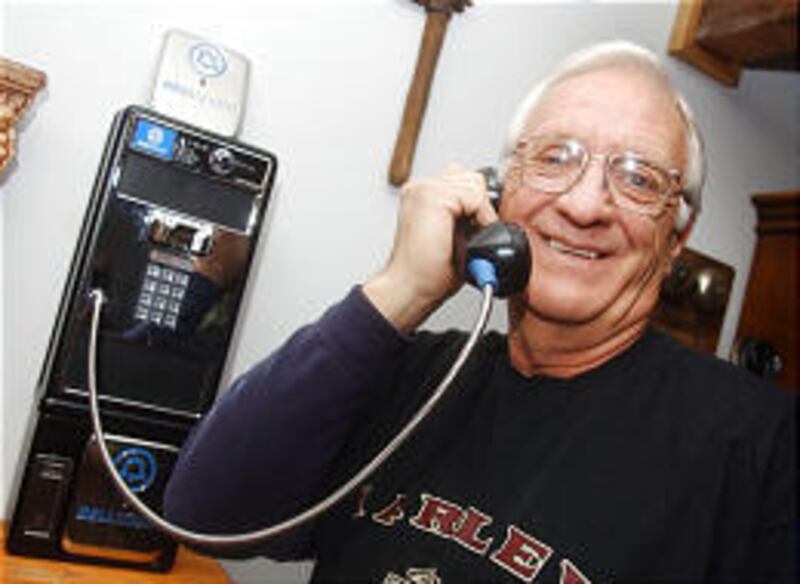 Hugh Bowen makes a call on his newly purchased pay phone in the living room of his Conyers, Ga., home on Tuesday.