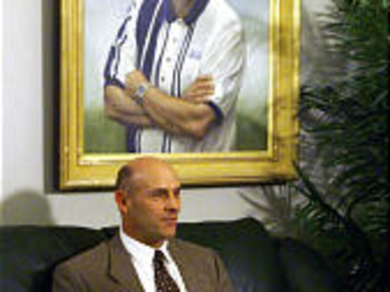 This photo is of Gary Crowton at the time of his hiring, posed under a portrait of LaVell Edwards. Edwards proved to be too tough an act to follow.