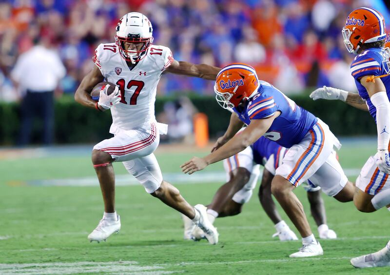 Utah Utes wide receiver Devaughn Vele, wearing white, tries to push Florida Gators long snapper Marco Ortiz as Utah and Florida play.