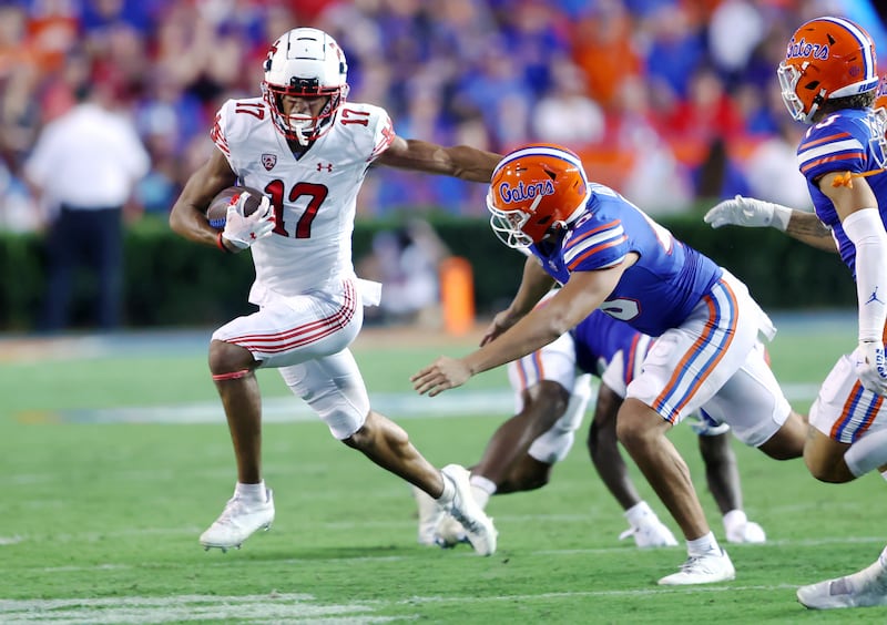 Utah Utes wide receiver Devaughn Vele, wearing white, tries to push Florida Gators long snapper Marco Ortiz as Utah and Florida play.