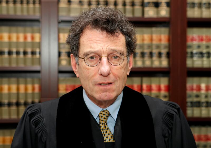 FILE – In this Jan. 11, 2018, file photo, Judge Dan Polster poses for a portrait in his office in Cleveland. Polster issued an order Wednesday, April 11, 2018, scheduling three Ohio trials for 2019 in local government lawsuits against the drug industry ov