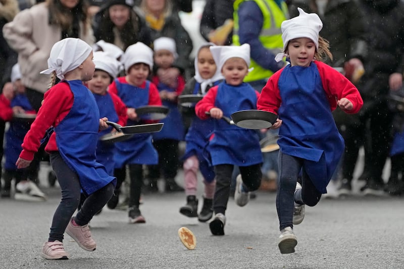 Schoolchildren from local schools take part in the children’s races prior to the annual pancake race in the town of Olney in England.