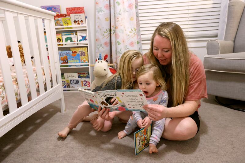 Ashley Llewellyn reads a book with daughters Lucy Llewellyn and Ruby Llewellyn at home in Spanish Fork on Monday, Jan. 24, 2022.