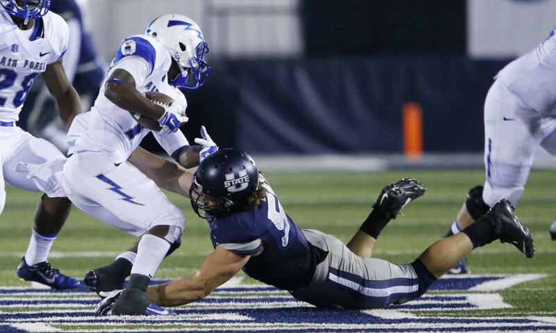 Utah State Aggies linebacker Zach Vigil (53) tackles Air Force Falcons wide receiver Garrett Brown (7) in Logan Saturday, Oct. 11, 2014.