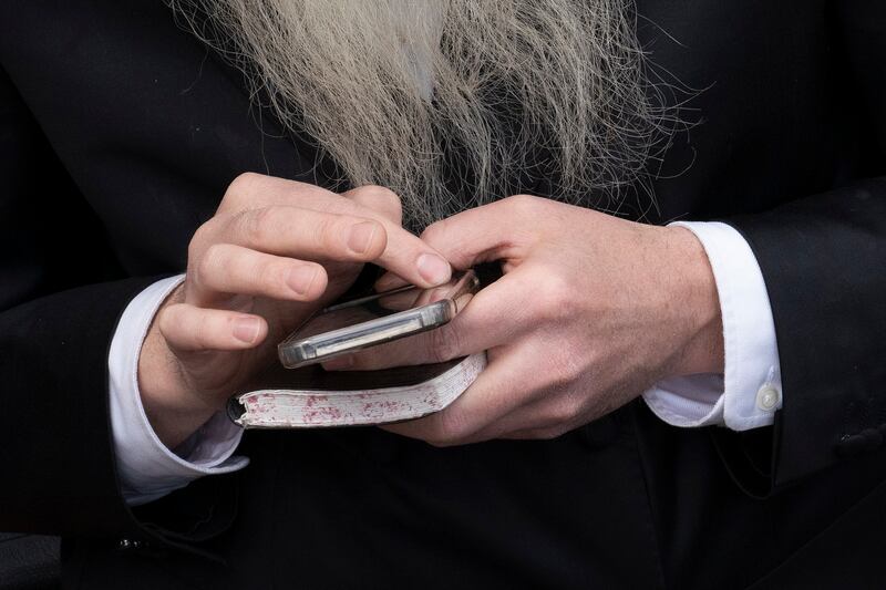 An older man uses a cellphone.