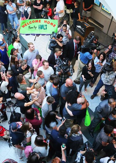Josh Holt and his wife Thamy are swarmed by family and friends as they arrive at the International Terminal in Salt Lake City International Airport on Monday, May 28, 2018.