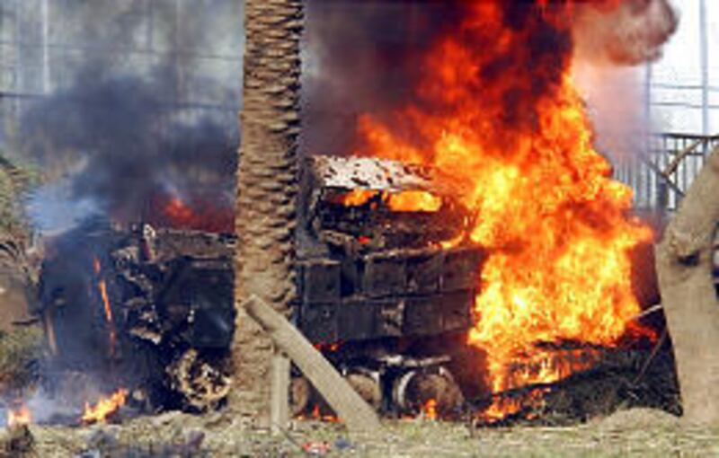 A U.S. Army armored vehicle burns on the airport highway in Baghdad. A roadside bomb exploded near convoy, injuring six soldiers.