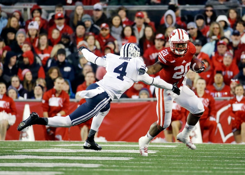 Wisconsin's James White tries to avoid BYU's Rob Daniel during game Saturday, Nov. 9, 2013, in Madison, Wis. Wisconsin won 27-17.