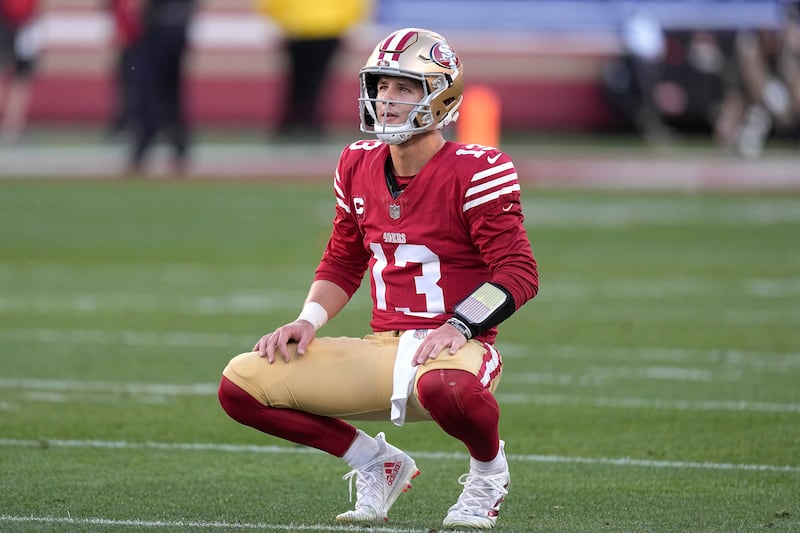 San Francisco 49ers quarterback Brock Purdy (13) crouches down on the field during the first half of the NFC championship game against the Detroit Lions, Sunday, Jan. 28, 2024.