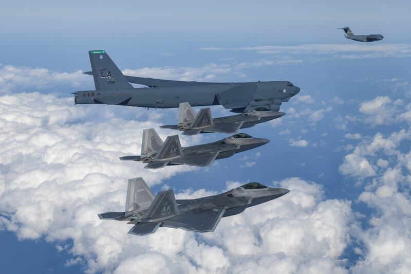 In this photo provided by South Korean Defense Ministry, a U.S. B-52 bomber, C-17, and U.S. Air Force F-22 fighter jets fly over the Korean Peninsula during a joint air drill in South Korea on Dec. 20, 2022.