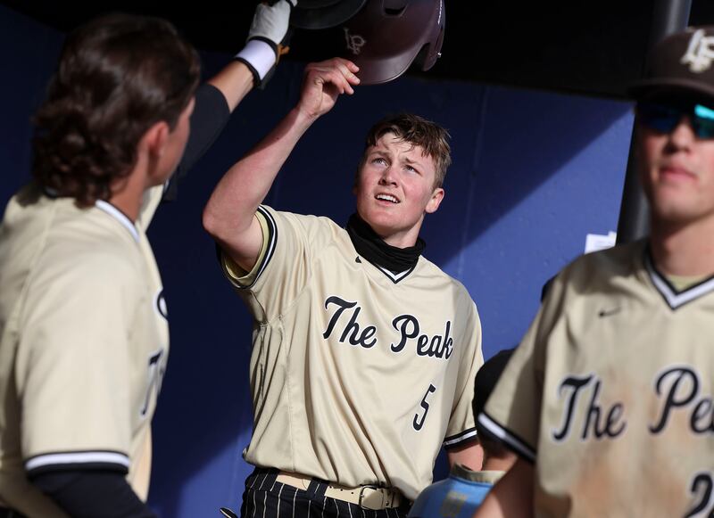 Lone Peak’s Jethro Johnsen, center, is congratulated after scoring against Riverton in a high school baseball game at Riverton High School.