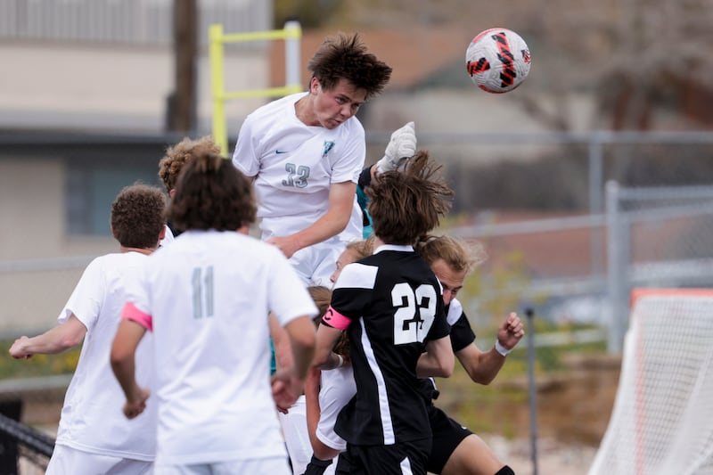 Farmington’s Jaden Petersen goes for a header during a high school soccer game against Davis.