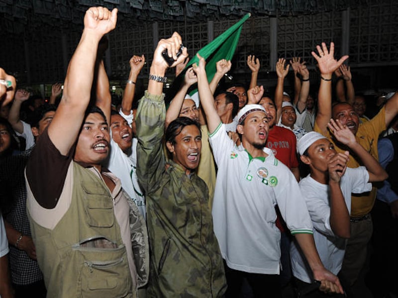 Opposition Pan-Malaysian Islamic Party supporters jubilate outside party headquarters in Kota Bahru, Malaysia, early today.
