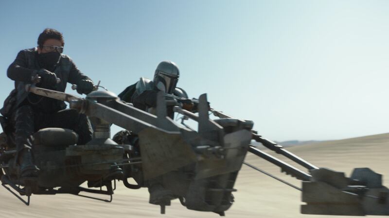 A photo of the Mandalorian on a speeder bike in episode five, “The Gunslinger.”