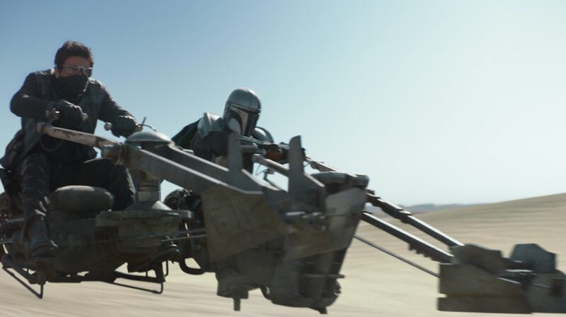A photo of the Mandalorian on a speeder bike in episode five, “The Gunslinger.”