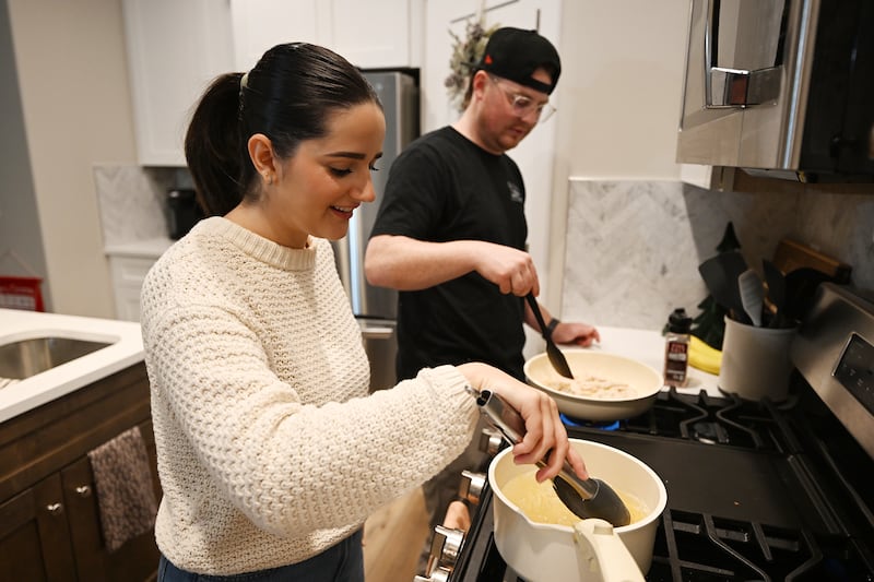 Kaitlyn Gordon and her husband, Zach Gordon, talk as they prepare a meal in their new home in Spanish Fork.