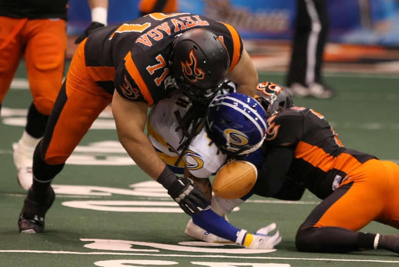 The Utah Blaze's Shannon Tevaga (#71) and Aaron Lesue tackle the Tampa Bay Storm's Chris Smith during a football game at the Energy Solutions Arena in Salt Lake City on Saturday, April 6, 2013.