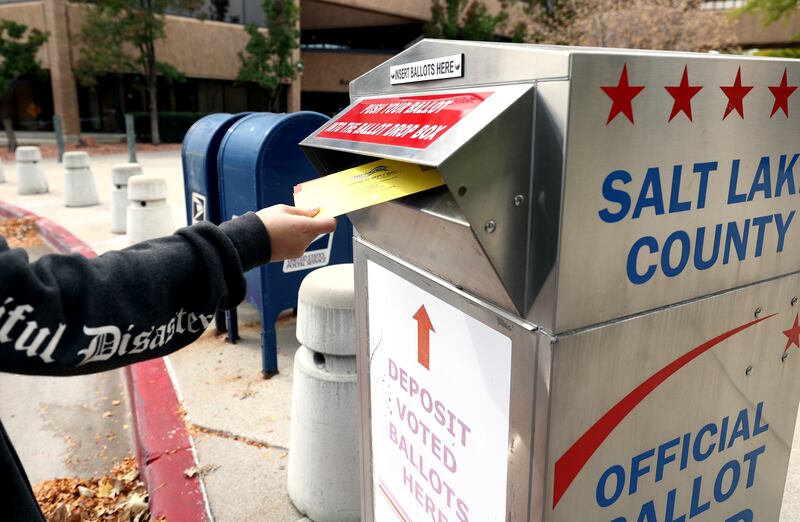 A voter drops a ballot into a box at the Salt Lake County Government Center in Salt Lake City on Monday, Oct. 18, 2021.