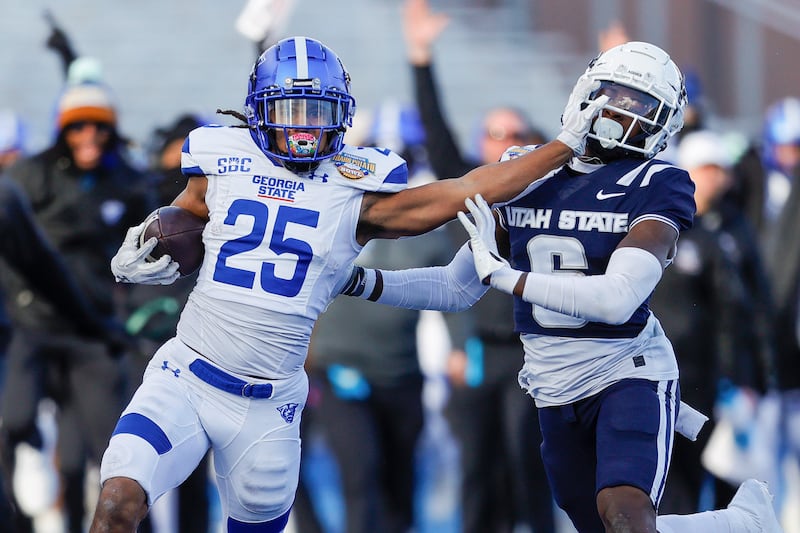 Georgia State running back Freddie Brock (25) stiff arms Utah State safety Ike Larsen (6) in the first half of the Famous Idaho Potato Bowl NCAA college football game, Saturday, Dec. 23, 2023, in Boise, Idaho. (AP Photo/Steve Conner)