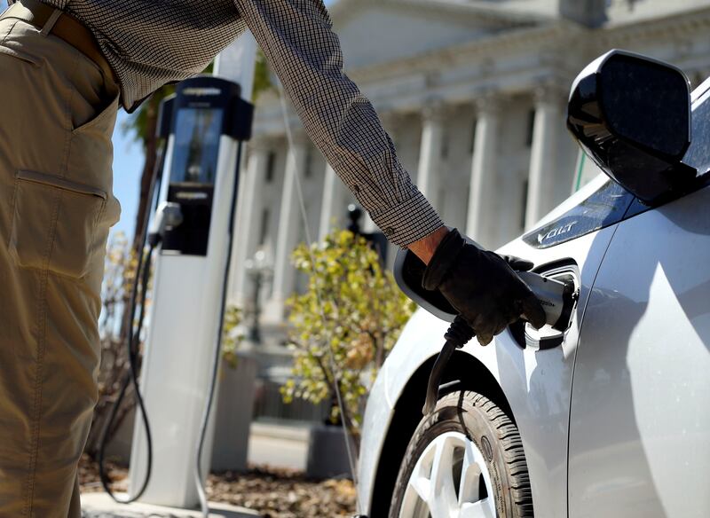 Jon Barney disconnects his electric car from a charging station at the Capitol in Salt Lake City on Sept. 3, 2020.
