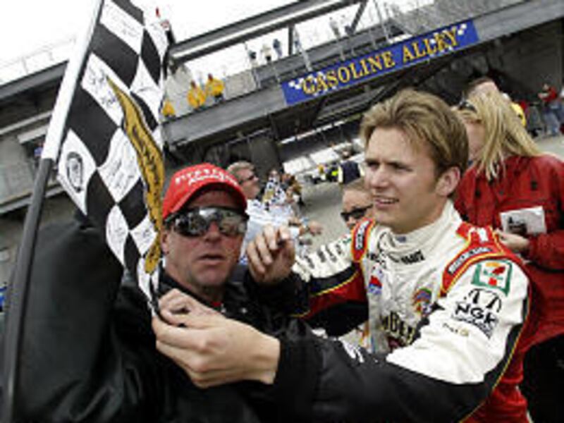 Indy Racing League driver Dan Wheldon of England signs an autograph.