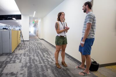 Kristen Johnson, left, talks to Cal Gaddis at CHG Healthcare Services' headquarters in Midvale on Wednesday, Aug. 8, 2018. Workers are wearing more casual attire as dress codes loosen, according to the Employers Council’s Miscellaneous Benefits & Pay Prac