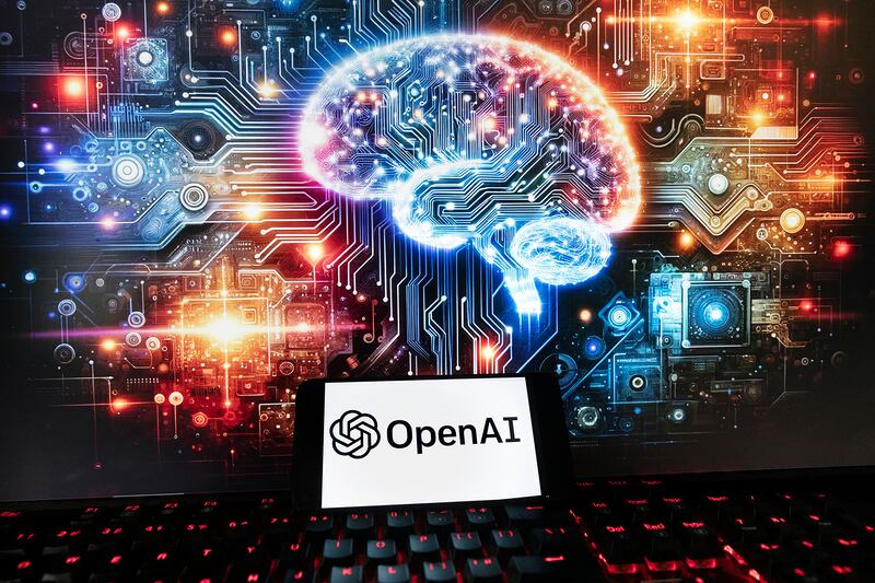 The OpenAI logo is displayed on a cellphone with an image on a computer monitor generated by ChatGPT’s Dall-E text-to-image model, Friday, Dec. 8, 2023, in Boston.