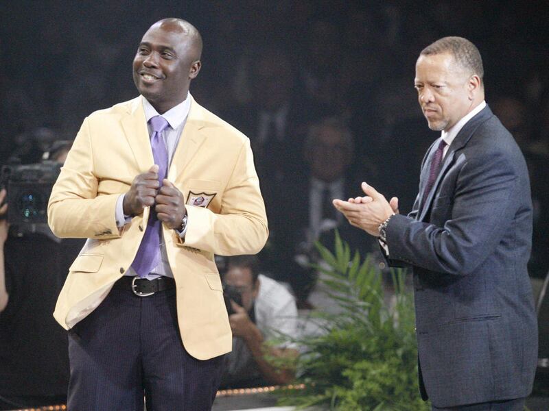 Marshall Faulk smiles at the crowd after receiving his gold jacket from Rocky Arceneaux at the Pro Football Hall of Fame Festival inductees dinner Friday, Aug. 5, 2011 at the Memorial Civic Center in Canton, Ohio. Arceneaux will be presenting Faulk for i