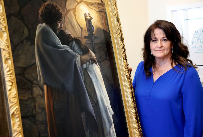 Liz Lemon Swindle poses for a portrait with her painting, “You Are Mine,” in her studio office in Provo, Utah.