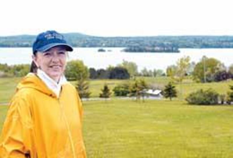 Norma Stewart of the St. Croix 2004 Coordinating Committee stands on the bank of the St. Croix River in Bayside, New Brunswick.