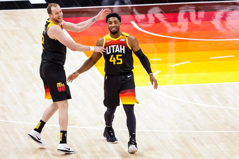 Utah Jazz guards Joe Ingles, left, and Donovan Mitchell laugh after Mitchell sank a 3-pointer against Orlando April 3, 2021.