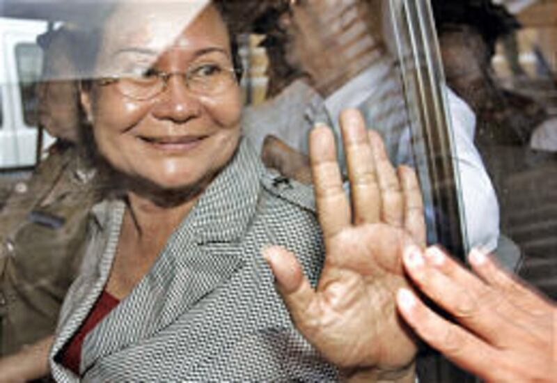 Thuong Nguyen "Cuc" Foshee of Orlando, Fla., smiles and reaches out to a family member as she leaves following her trial Friday in Ho Chi Minh City, Vietnam. She and six others were convicted of terrorism.