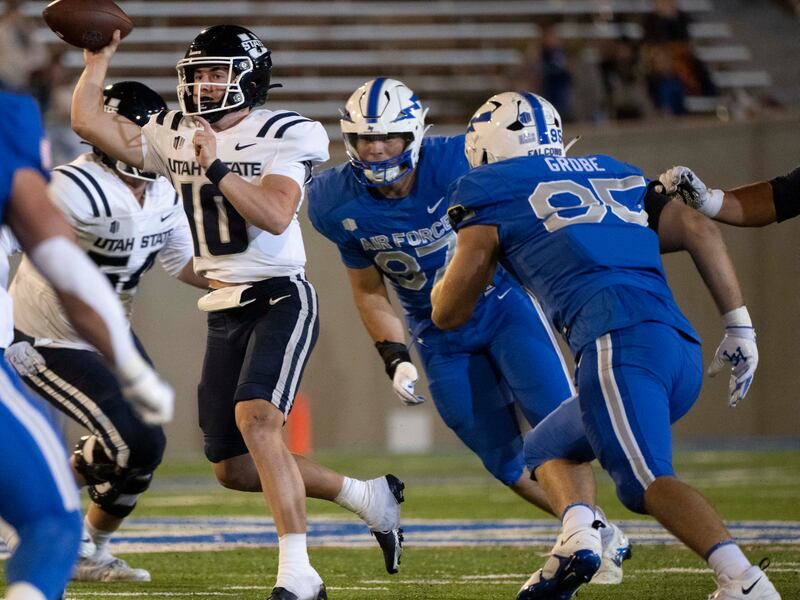 Air Force defensive lineman Caden Blum (87) and defensive end Daniel Grobe (95) pressure Utah State quarterback McCae Hillstead.