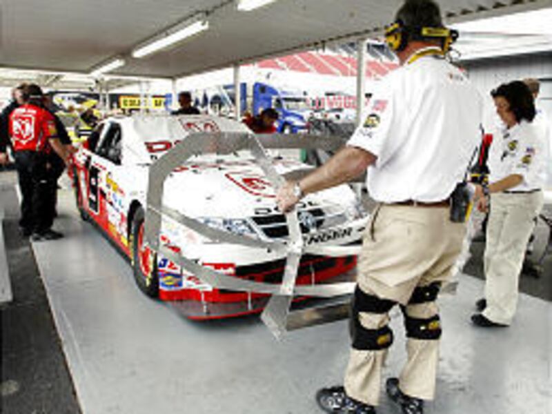 NASCAR official Jerry Hines, foreground right, checks out the new Car of Tomorrow.