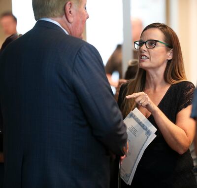 Kem Gardner, left, talks with an upset Candi Huff, of the Epilepsy Association of Utah, after a broad coalition of Utah community leaders announced its opposition to Utah's medical marijuana ballot initiative during a press conference at the Utah State Of