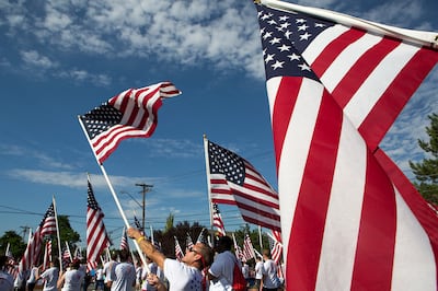 Alex Saville, center, and others with Utah Healing Field wave American flags the during the Days of '47 Parade in Salt Lake City on Tuesday, July 24, 2018.