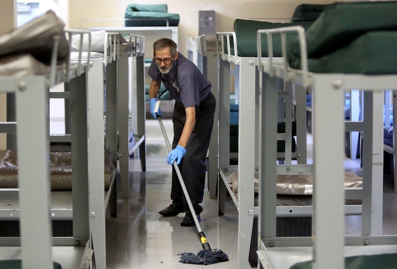 FILE - John Hargreaves cleans the single men's dorm at the Road Home in Salt Lake City on Friday, Aug. 4, 2017.