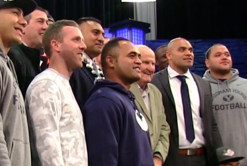 New BYU running backs coach Reno Mahe, in blue sweatshirt, poses with first-year head coach Kalani Sitake, former head coach LaVell Edwards and several other former and current BYU players at a press conference in Provo Monday, Dec. 21, 2015. Sitake was i