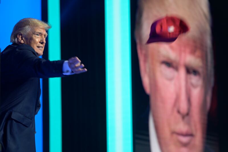 Former President Donald Trump tosses hats into the crowd during the Turning Point USA Student Action Summit.