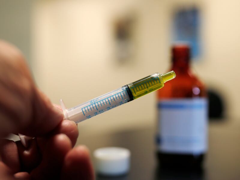 FILE - In this Nov. 6, 2017, file photo, a syringe loaded with a dose of CBD oil is shown in a research laboratory at Colorado State University in Fort Collins, Colo.