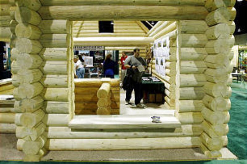 Visitors tour log homes at the Log Home and Timber Frame Expo at the South Towne Expo Center on Friday.