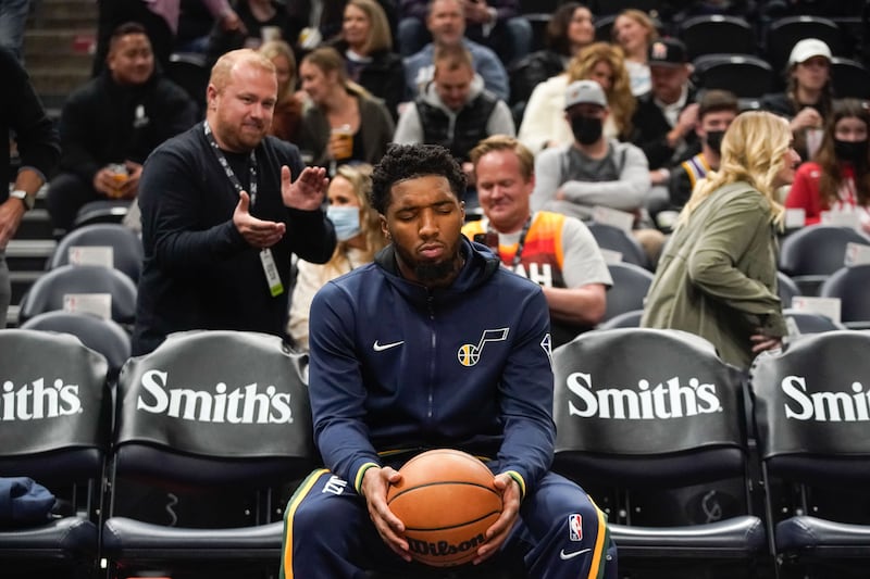 Fans pass behind Utah Jazz guard Donovan Mitchell prior to game against Charlotte in Salt Lake City, Dec. 20, 2021.