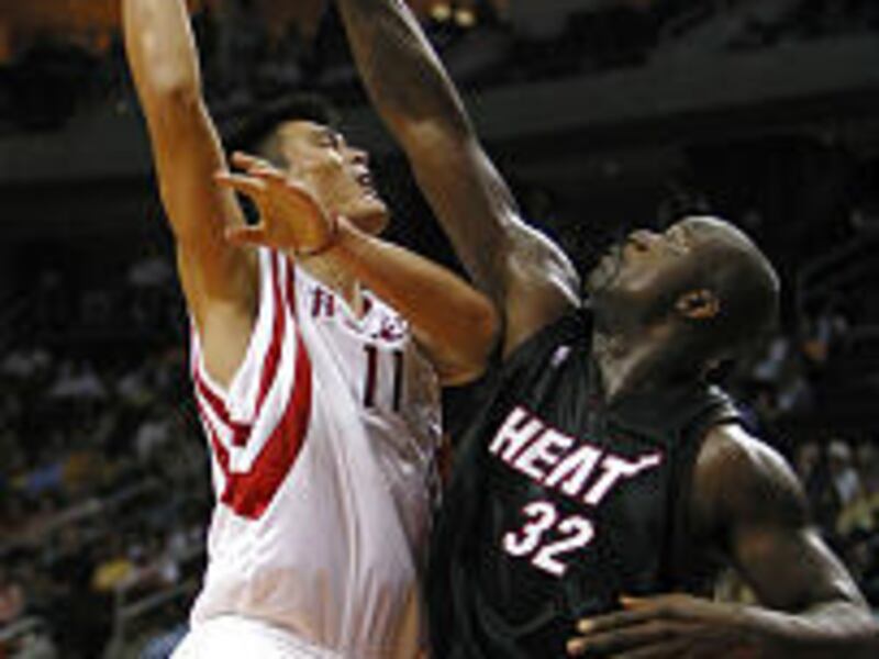Miami's Shaquille O'Neal (32) fouls Houston's Yao Ming in NBA preseason action Sunday.