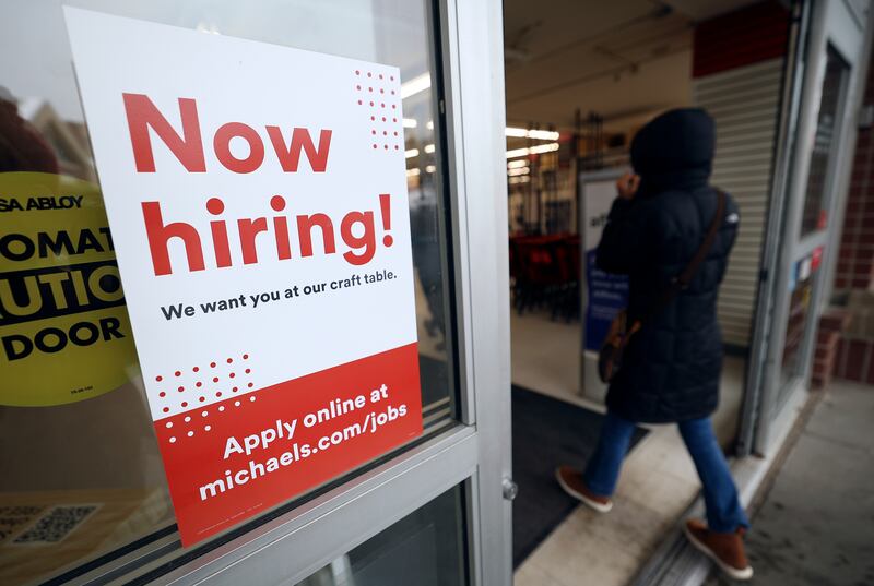 A “Now hiring!” sign is pictured on the door to Michaels in Salt Lake City.