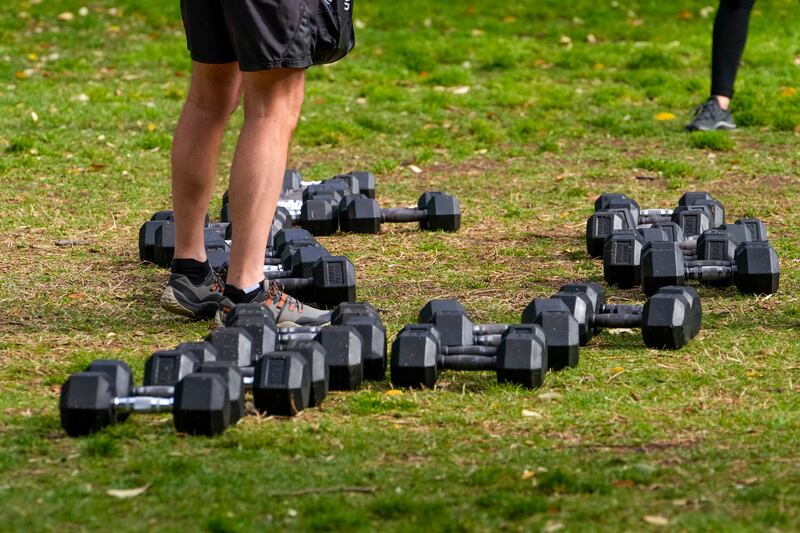 A client stands among a selection of weights in a park in the eastern suburbs of Sydney, Australia.