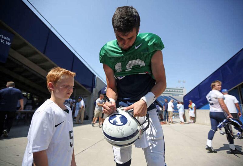 Tanner Mangum signs an autograph for Ashton Thompson after a BYU scrimmage at LaVell Edwards Stadium in Provo on Saturday, Aug. 22, 2015.