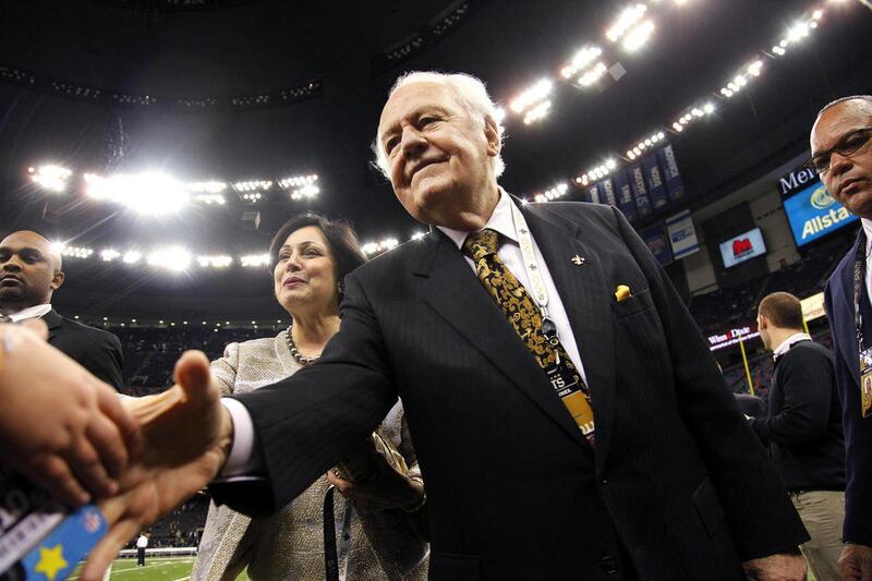 FILE - This Jan. 1, 2012 file photo shows New Orleans Saints owner Tom Benson and his wife Gayle Benson shaking hands before an NFL football game against the Carolina Panthers in New Orleans. A person familiar with the deal says the NBA has agreed to sell