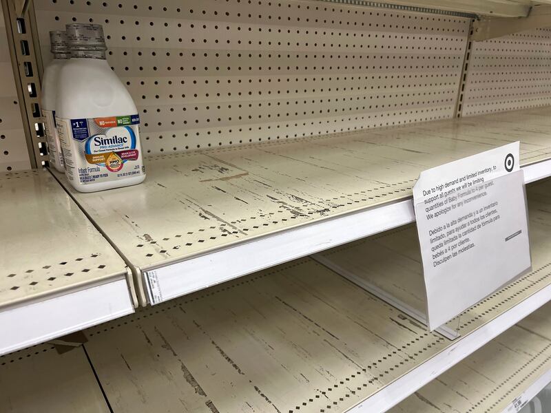 A sign posted on nearly empty shelves a local store in the Salt Lake Valley lets shoppers know about infant formula shortages.