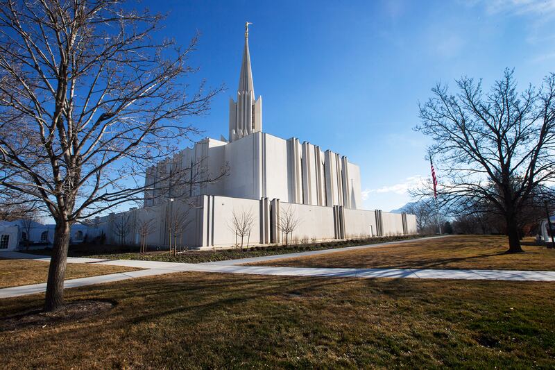 The exterior of the Jordan River Utah Temple on a clear day with blue skies.